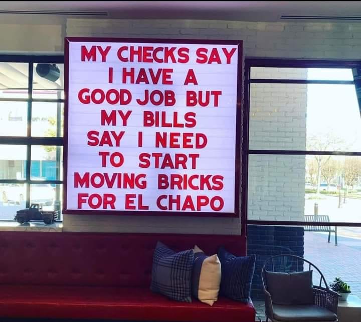 This meme is a humorous take on a common phrase. The image shows a sign with the text "My checks say I have a good job, but my bills say I need to start moving bricks for El Chapo." The meme is poking fun at the idea that someone's financial situation is not as stable as they claim, with a humorous twist on the phrase "my checks say" and the absurdity of needing to start moving bricks for a notorious figure.